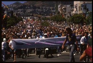 Massive crowd marching in the San Francisco Pride Parade, carrying banner reading 'Mayors contingent': Art Agnos waving to the crowd from the back of an automobile