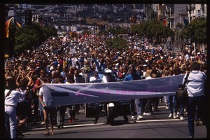 Massive crowd marching in the San Francisco Pride Parade, carrying banner reading 'Mayors contingent': Art Agnos waving to the crowd from the back of an automobile