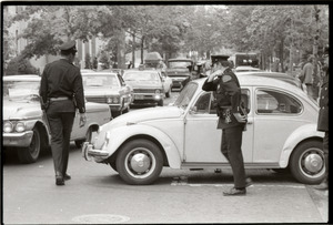 May Day concert and demonstrations: police inspecting Volkswagen Beetle used as blockade