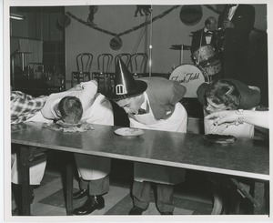 Clients competing in a pie eating contest at Halloween party