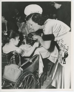 Woman in chef's hat feeding turkey to child in wheelchair