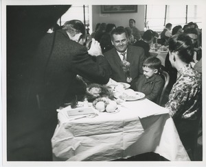 Man photographing young client at Thanksgiving celebration