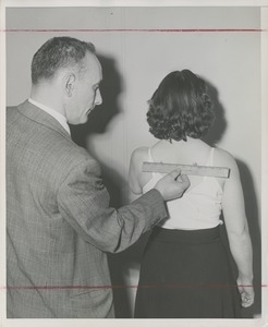 A man measures a patient's back