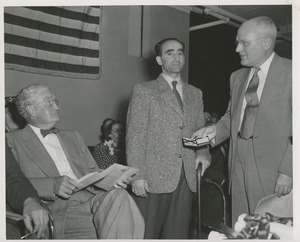 Unidentified man showing his business card to Bruce Barton at an ICD event