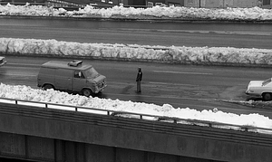 Police officer walking among cars on snowy highway in Boston