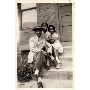 A young Reverend Michael E. Haynes poses with two unidentified girls