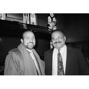 Portrait of two unidentified men in suits and ties standing in the Jorge Hernandez Cultural Center.