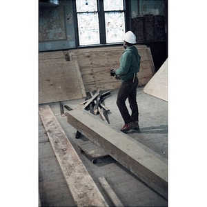 Construction worker surrounded by boards in the former church sanctuary that is being turned into a cultural center.