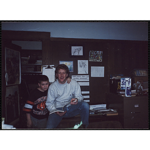 A boy posing with his arm around a male staff member