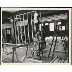 Two men framing an interior wall with wood studs during the Boys' Clubs of Boston Charlestown Clubhouse renovation