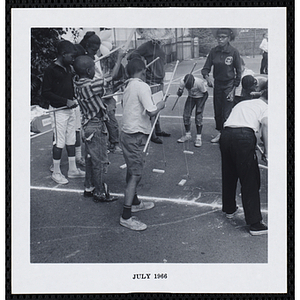 A group of boys play a fishing game on a playground during Tom Sawyer Day