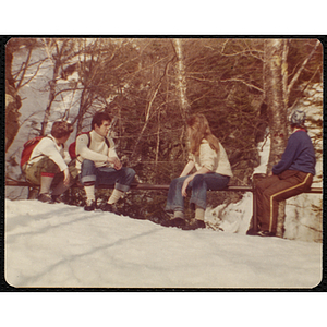 Four teenagers take a break while cross-country skiing