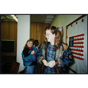 Three girls stand near a history-themed bulletin board at a Tri-Club event