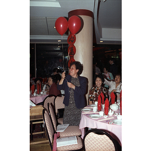 Guest holding balloons at the Chinese Progressive Association's 20th Anniversary and the Workers' Center's 10th Anniversary Celebration