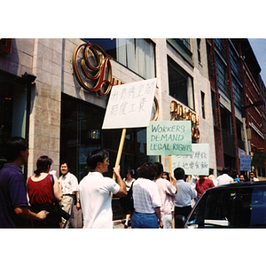 Demonstrators holding protest signs, picketing outside of Dynasty Restaurant to get back wages for workers