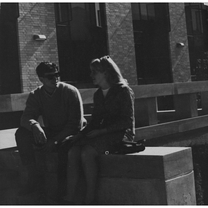 Two Northeastern students sitting outside an NU building