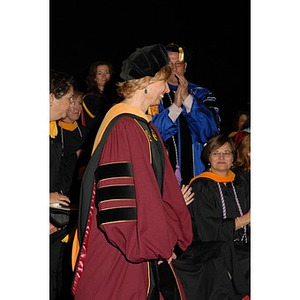 Carol Glod, a professor from the School of Nursing, walking across the stage at the School of Nursing convocation ceremony