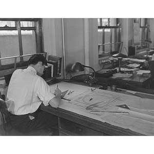 Northeastern engineering student sits at a drafting table on a co-op job