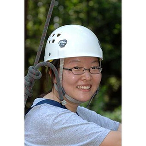 Qinrui Pang wears a helmet at the Torch Scholars Project Adventure Ropes Course