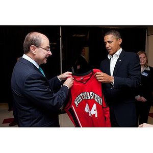 President Obama receiving a basketball jersey from University President Aoun
