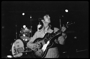 John Lennon (the Beatles) playing guitar in concert at D.C. Stadium