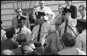 Police officers being interviewed after arresting Abbie Hoffman for wearing an American flag shirt