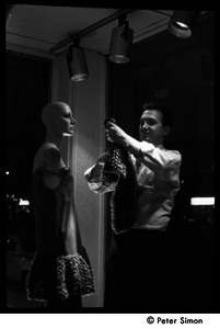 Jean Levy dressing a mannequin in a window display at Cyreld's boutique, Coolidge Corner