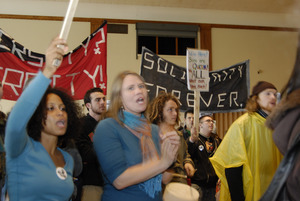 UMass student strike: strikers in the Student Union ballroom holding banners and cheering