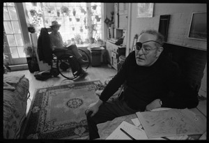 W. Eugene Smith, seated at a desk in his home