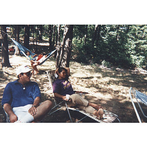 A man and woman sit in lawn chairs at a picnic event