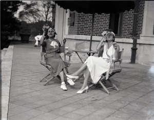 Mrs. Carl Miller and Gertrude Kear (?) seated on the verandah, smoking