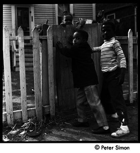 African American children playing by a gate