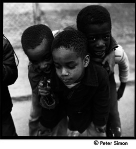 Group of three African American boys playing with a toy dart gun