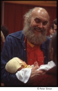 Ram Dass holding a baby after a lecture at Boston University