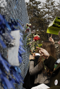 Justice for Jason rally at UMass Amherst: protesters in support of Jason Vassell placing flowers in a chain link fence