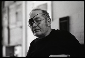 W. Eugene Smith, seated at a desk in his home