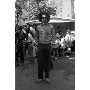 Full-length portrait of a Hispanic American man wearing sunglasses at a Latino street festival