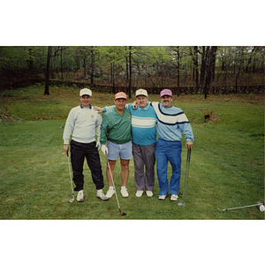 A four-man golf team standing with their arms around each other at a Boys and Girls Club Golf Tournament