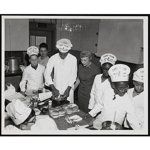 Members of the Tom Pappas Chefs' Club and two unidentified women participate in a cooking demonstration in Roxbury, Massachuestts