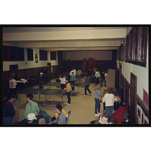 Children play table tennis in a hall