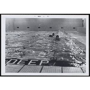 Two boys swim in a natorium pool