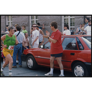 A man runs by cheering spectators during the Bunker Hill Road Race