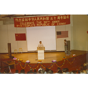 Man speaks at the 30th anniversary celebration of the People's Republic of China held in the Josiah Quincy School auditorium