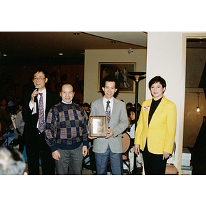 Lei Jing Restaurant construction worker holds an award at a dinner event