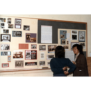 Guests and bulletin board at an International Workers' Day event