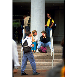 Students conversing while sitting on steps of Snell Library