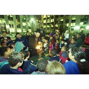 A rabbi lights Hanukah candles during the Holiday Celebration on Krentzmen Quad