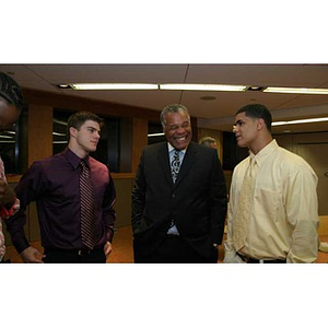 Joseph Bordieri and Danny Vazquez converse with a man at the Torch Scholars dinner