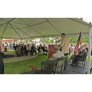 A man speaks under a tent at the Veteran's Memorial groundbreaking ceremony