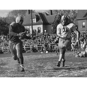 Two football players run during a game